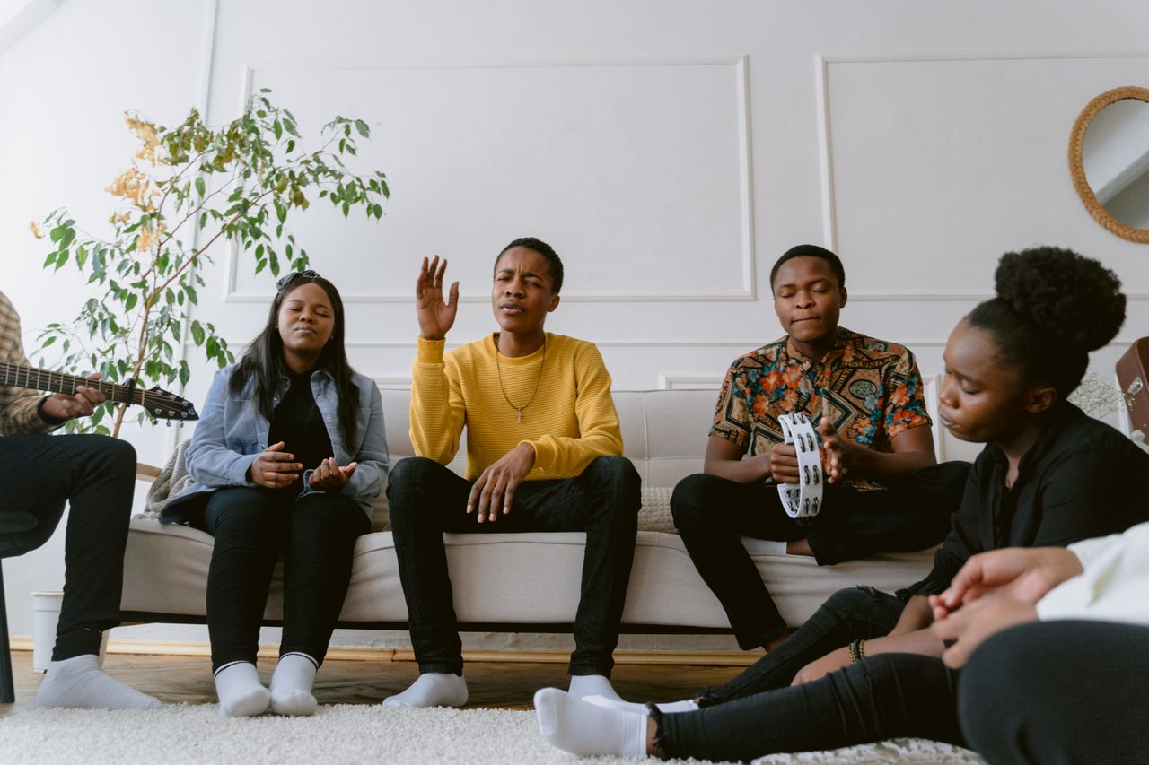 A diverse group of friends enjoying music together in a cozy living room setting.